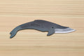 Whale-shaped utility knife with dark steel finish and silver cutting blade