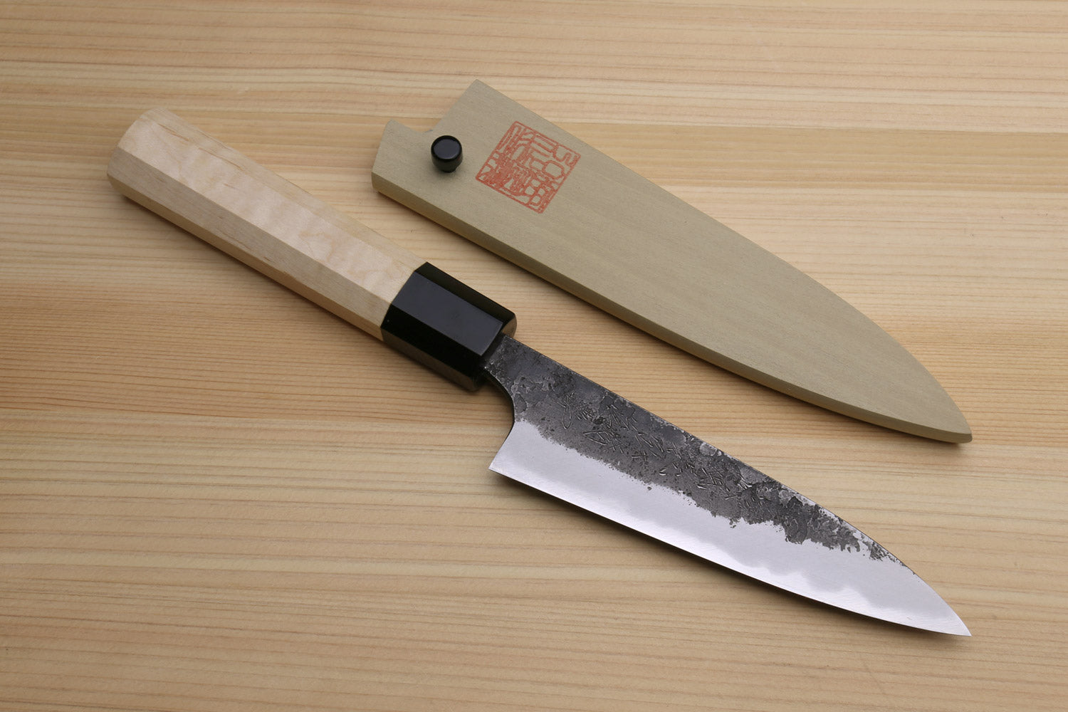 Japanese petty utility knife with camphor wood handle and white blade with speckling