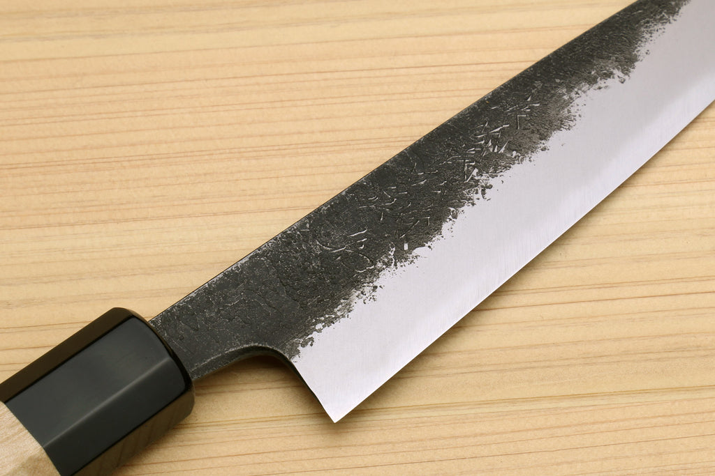 Petty utility knife blade showing dark speckled pattern and sharp cutting edge