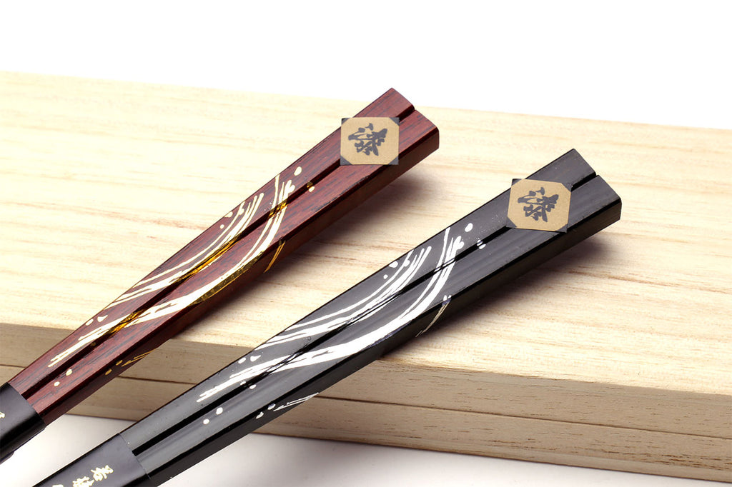 Lacquered chopsticks with floral end caps, red and black with gold and white inlay