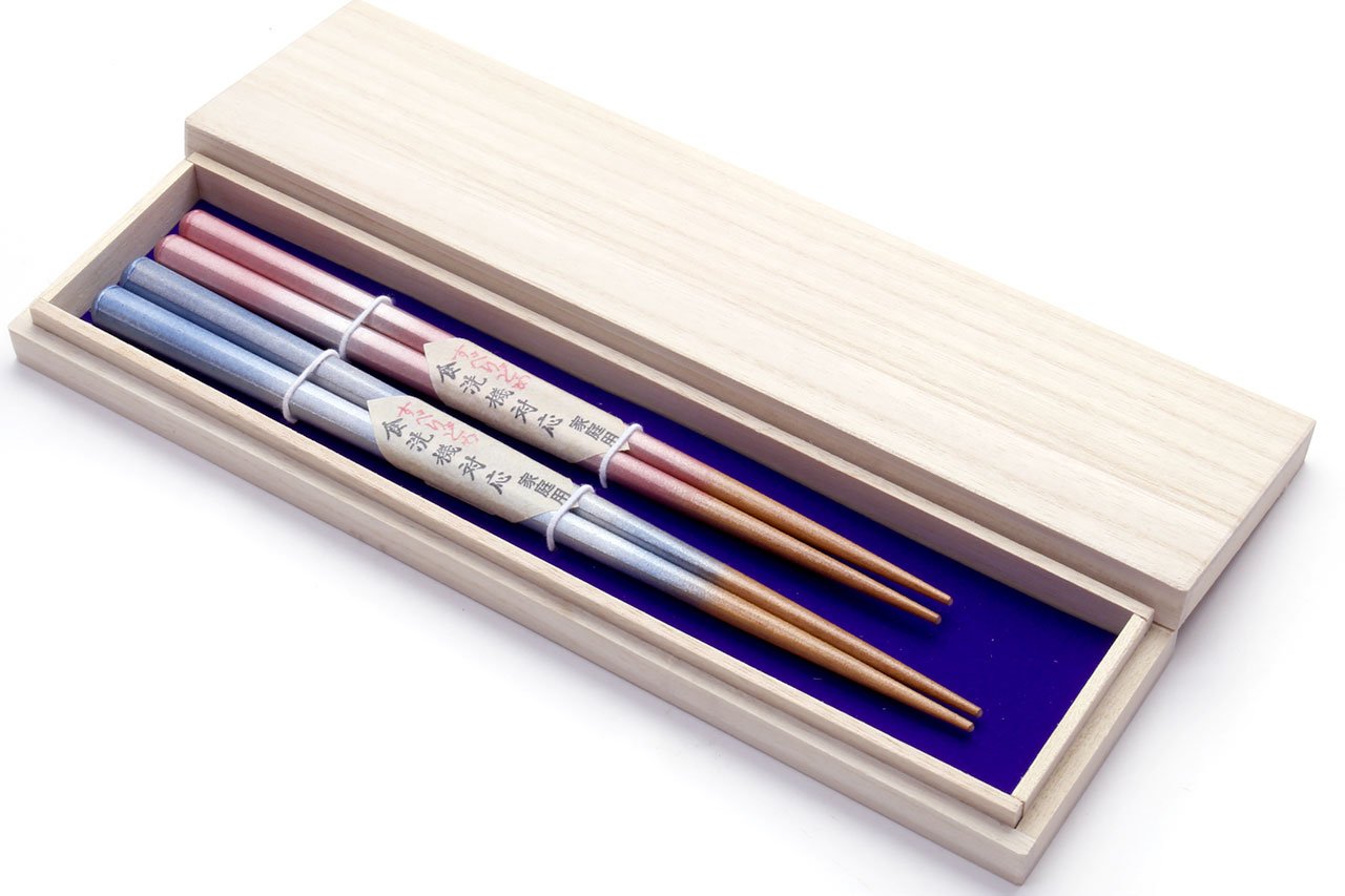 Pale wood chopstick case with pink and light-blue striped wooden chopsticks inside