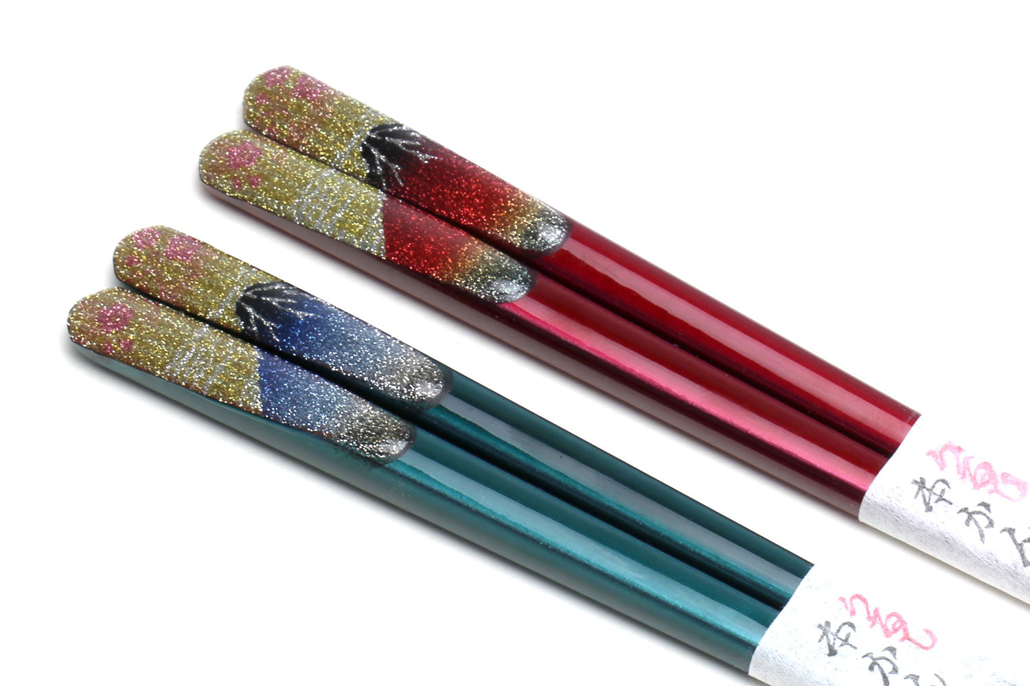 Four glitter lacquer chopsticks with red and teal shafts and speckled ends