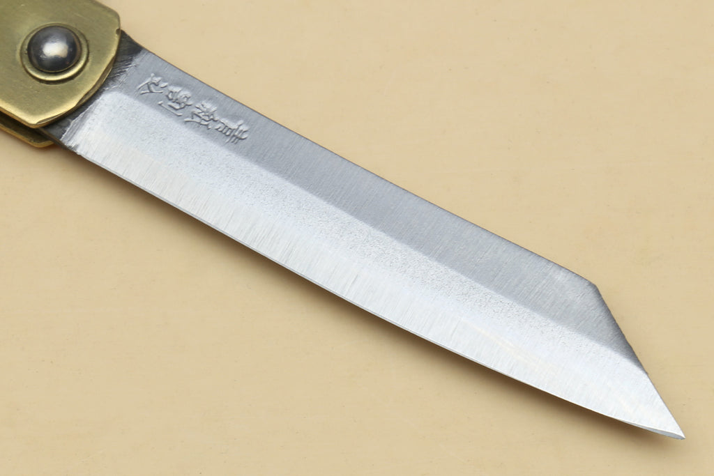 Kiridashi pocket knife blade close-up with etched steel surface and pointed tip