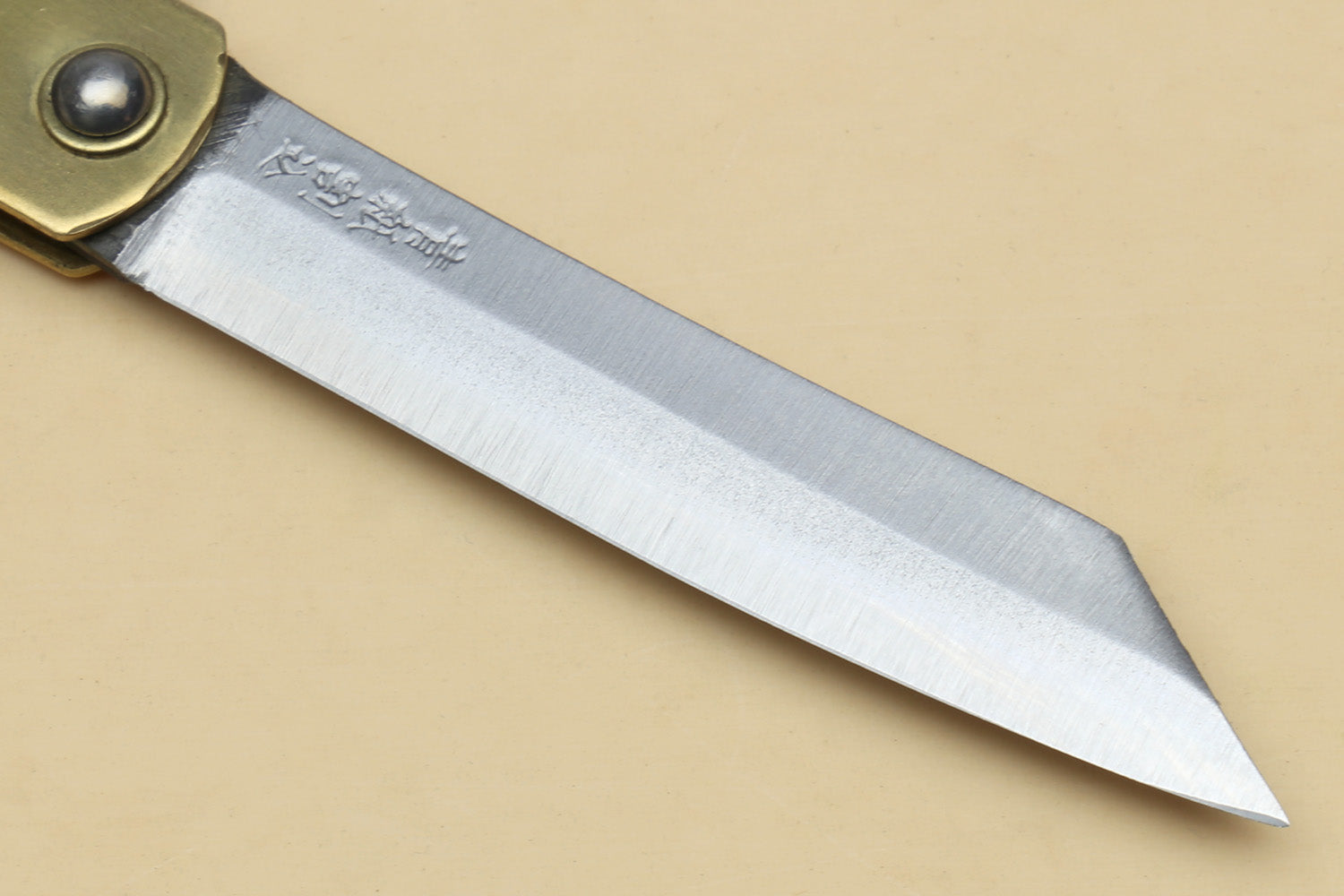 Kiridashi pocket knife blade close-up with etched steel surface and pointed tip