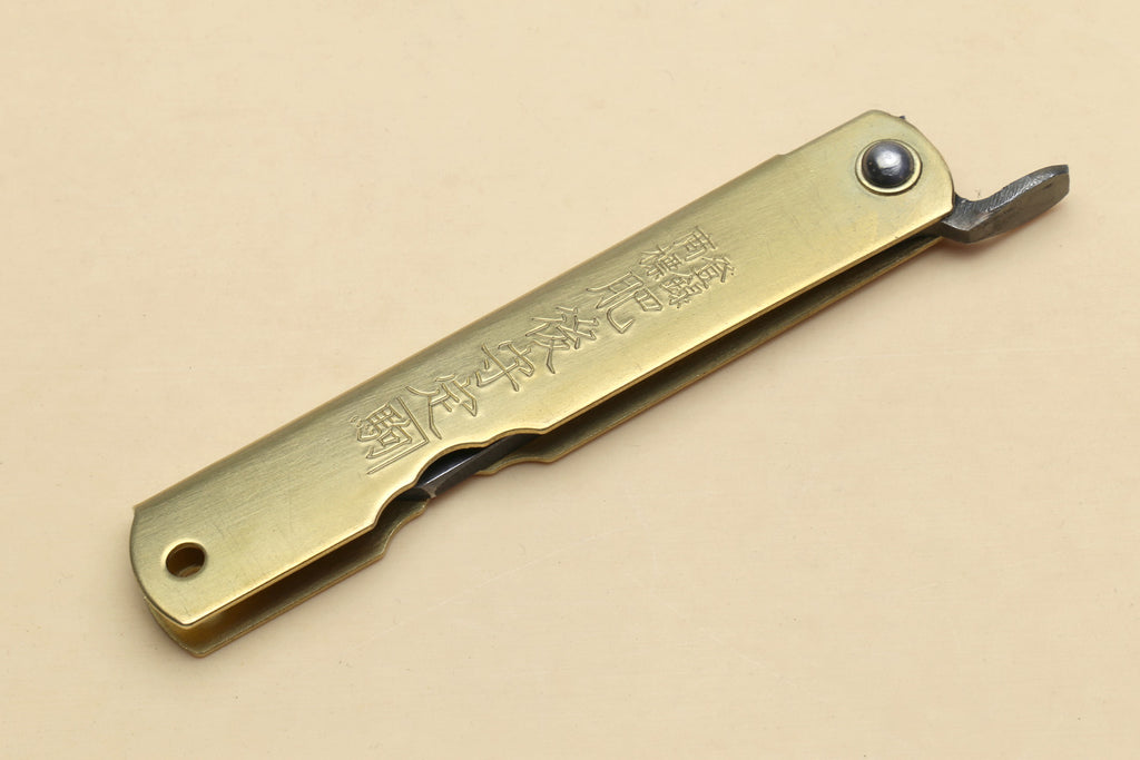 Kiridashi pocket knife with gold handle and visible rivet, single pointed blade