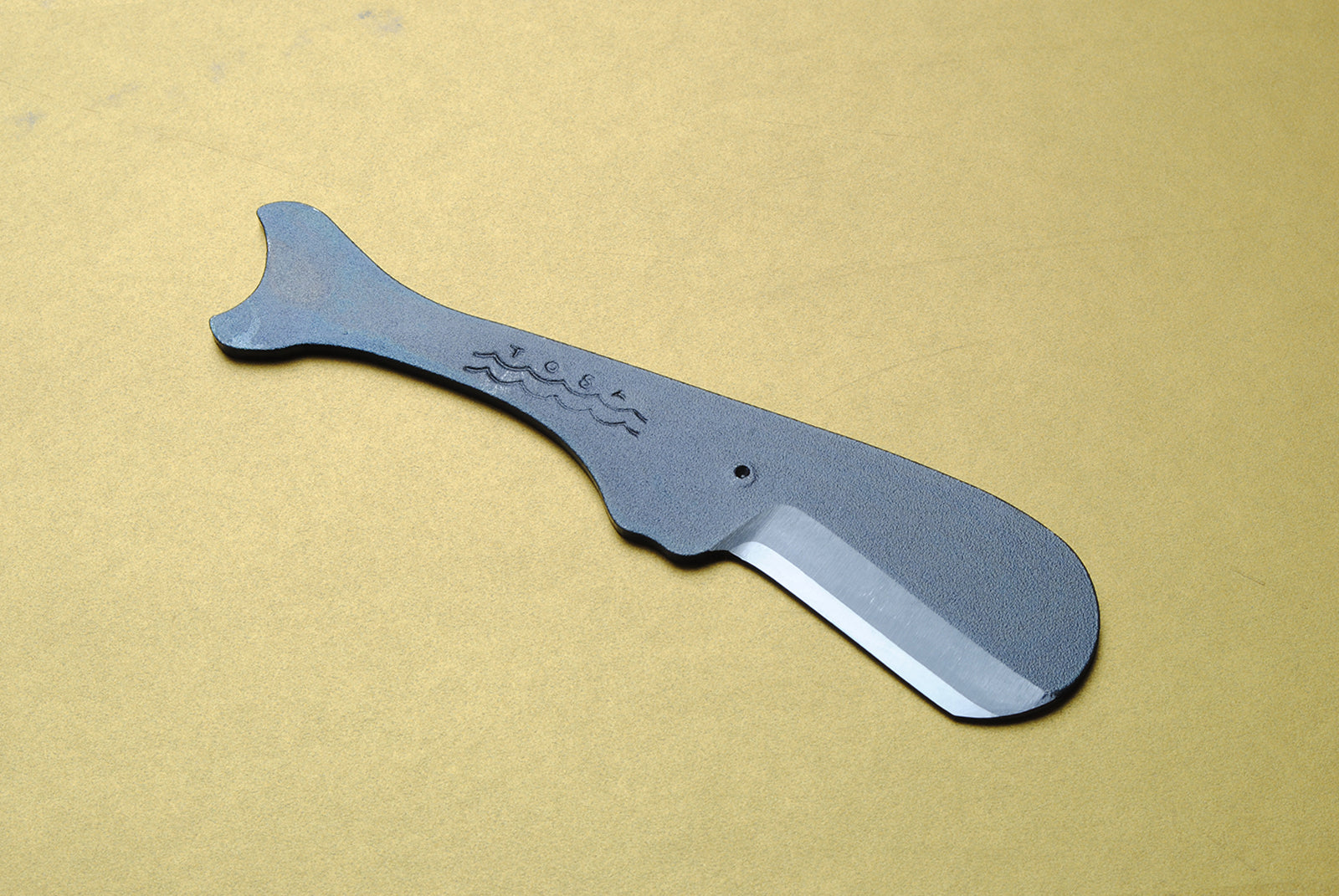 Utility knife with dark kurouchi finish, whale-shaped handle and tapered blade