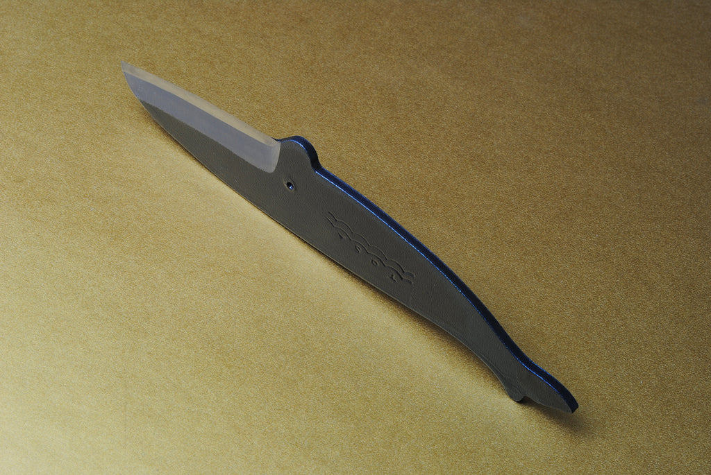 Japanese utility knife in dark steel with wave pattern etching along the blade