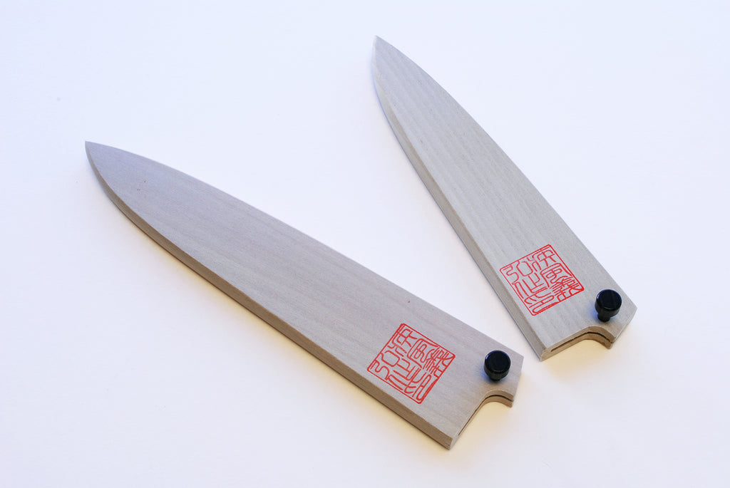 Pair of petty knife blade covers in natural wood with black knobs and red stamp.