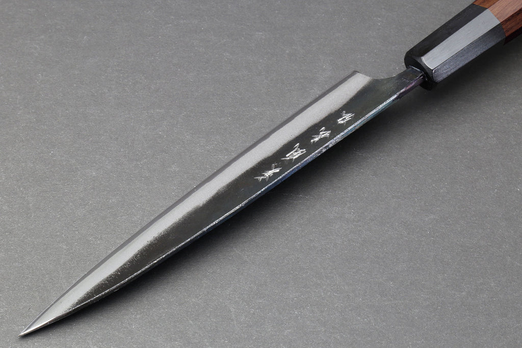 Petty utility knife with pointed tip, kurouchi blade, and dark wood handle