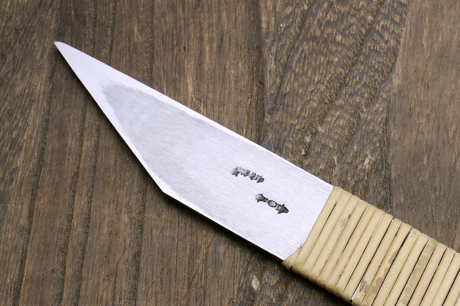 Kiridashi utility knife close-up of stamped steel blade and ribbed light wooden handle