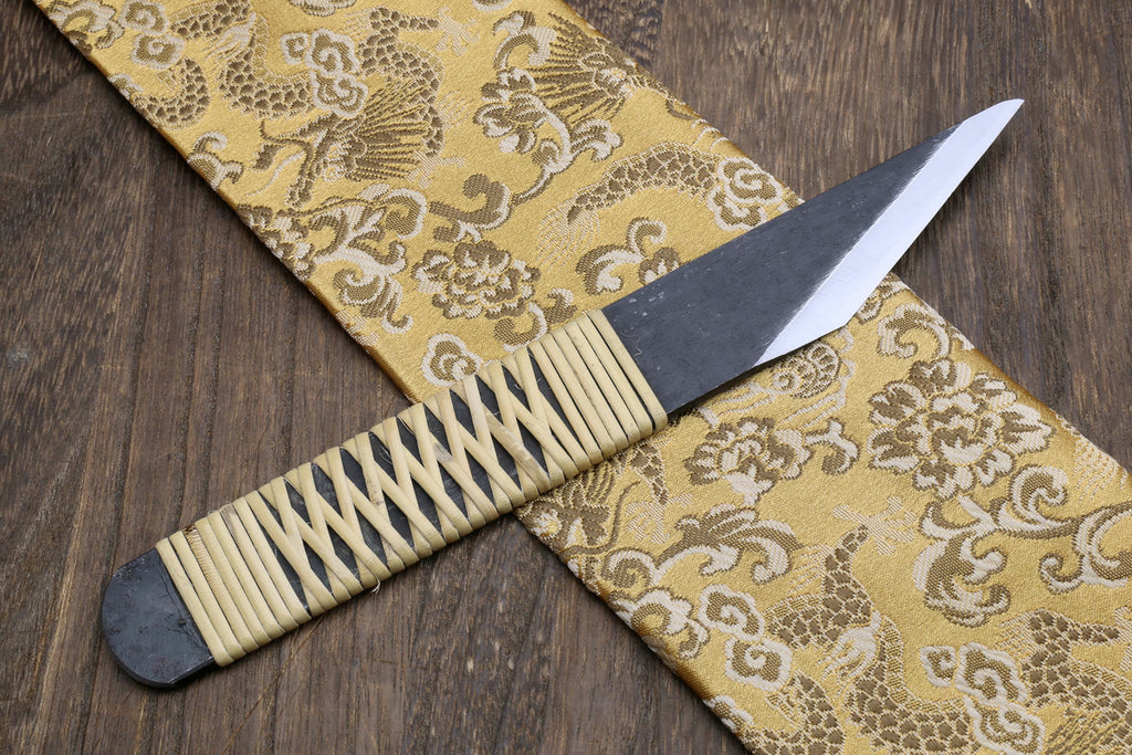 Kiridashi utility knife with ribbed wood handle and dark blade showing sharp tip