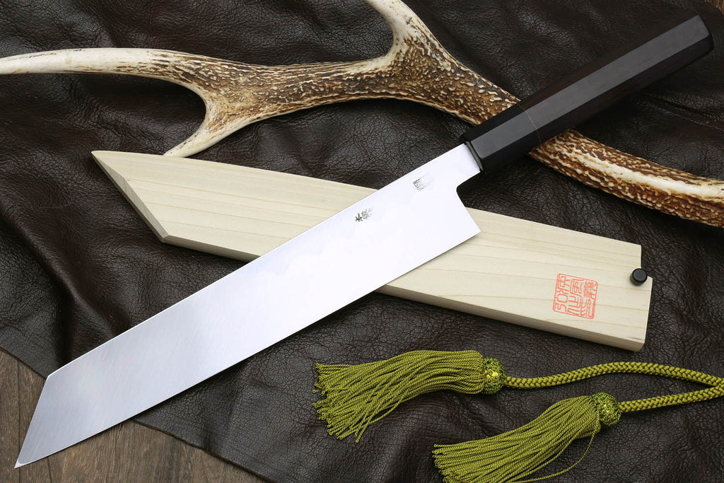 Multipurpose chef knife with silver blade and black handle, light wood sheath
