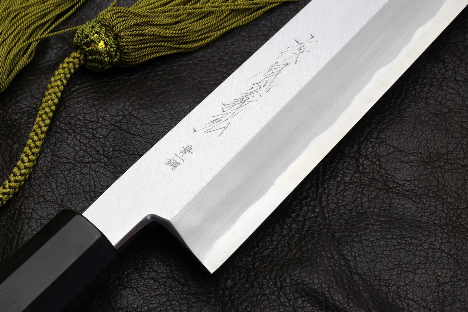 Multipurpose chef knife blade close-up with engraved markings on silver steel