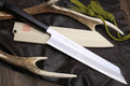 Multipurpose chef knife with silver blade, black handle, light wood sheath