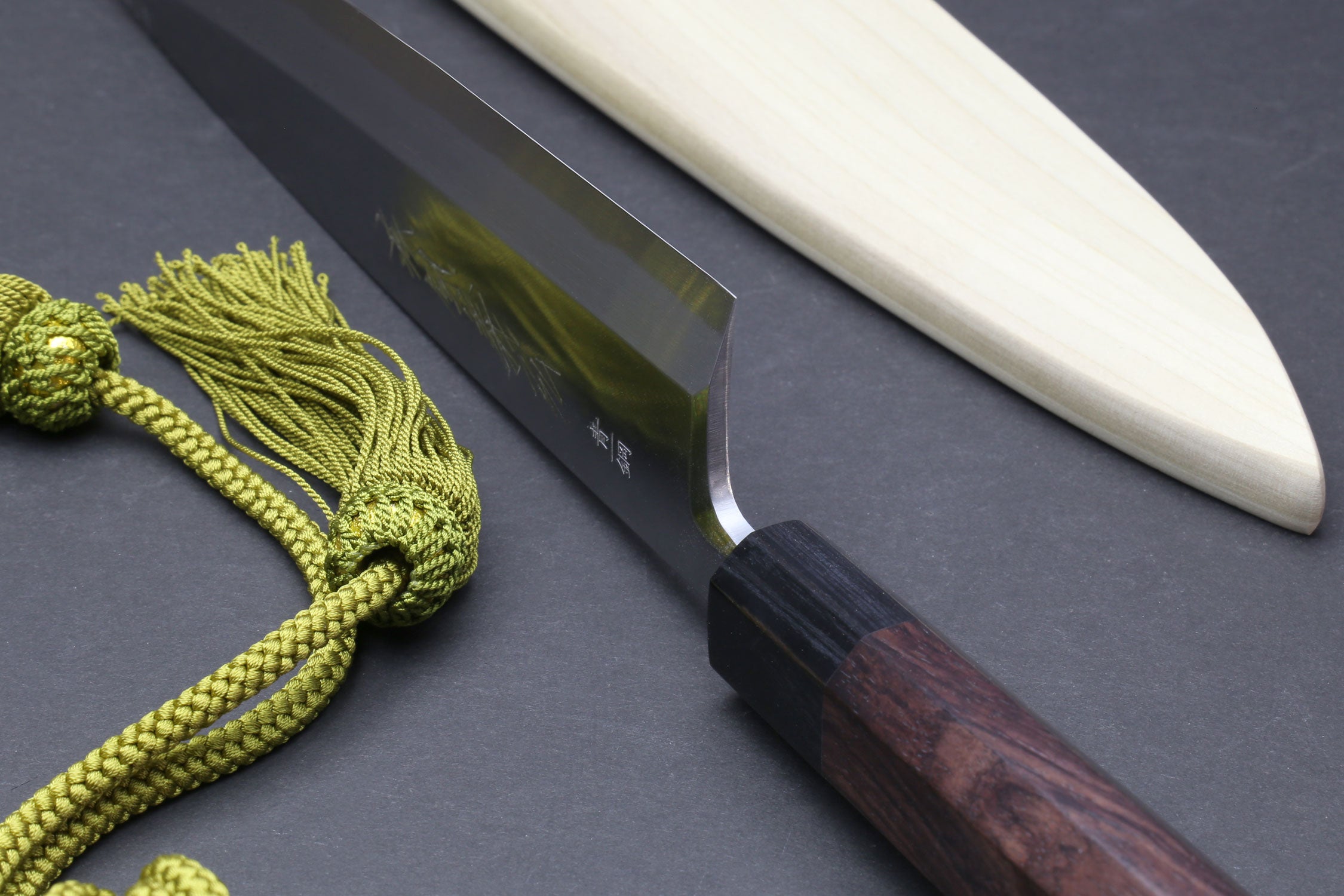 Japanese chef knife with dark wooden handle and light wooden saya