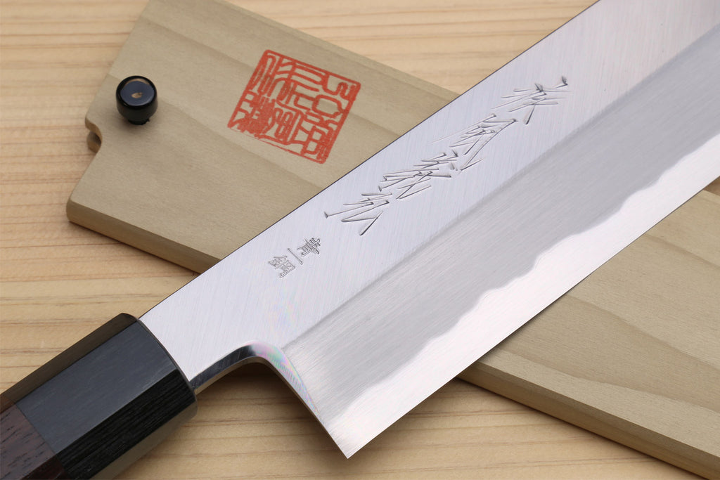Japanese vegetable knife close-up with engraved pale blade and dark rosewood handle