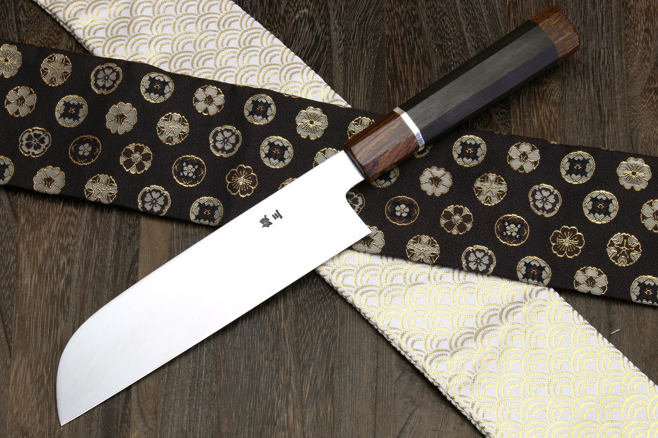 Japanese chef knife close-up with mirror-polished blade and dark wooden handle