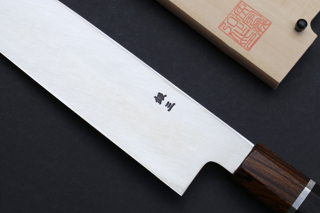 Japanese chef knife blade close-up with engraved markings, ebony handle