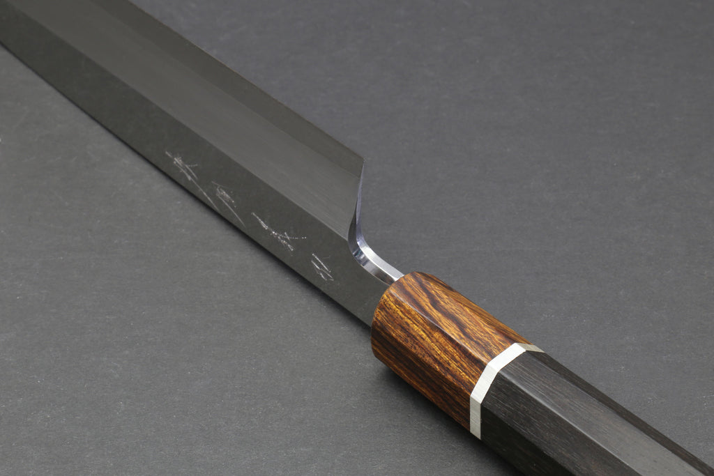 Japanese chef knife angled view with engraved blade and dark wood handle