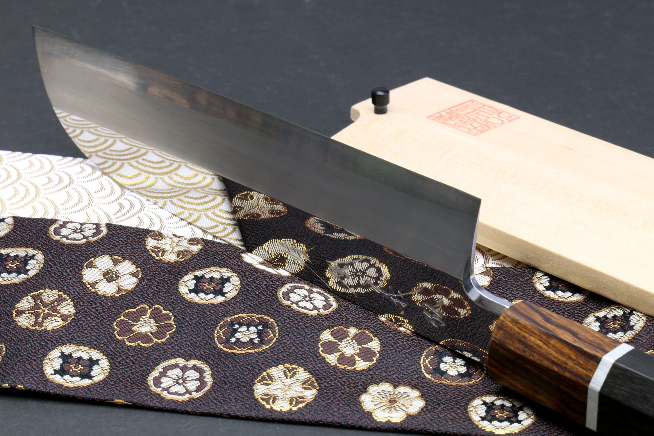 Japanese chef knife showing flat grind blade and ebony handle with silver ring