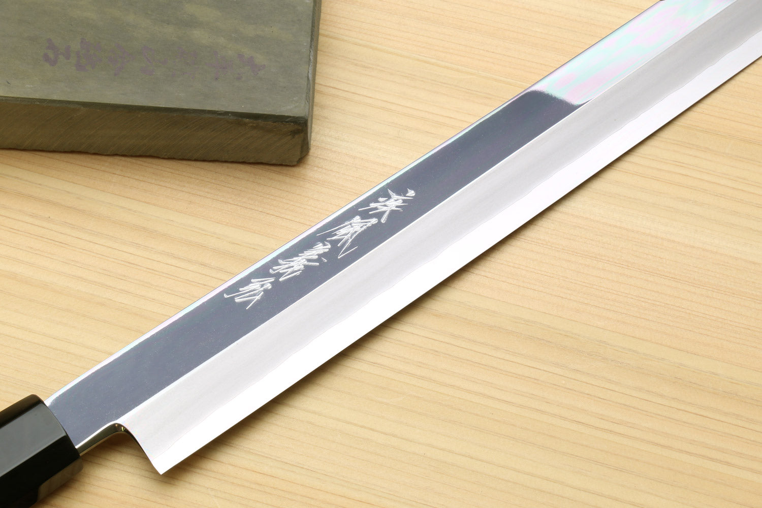 Mirror-polished tuna knife blade with engraved markings and ebony handle