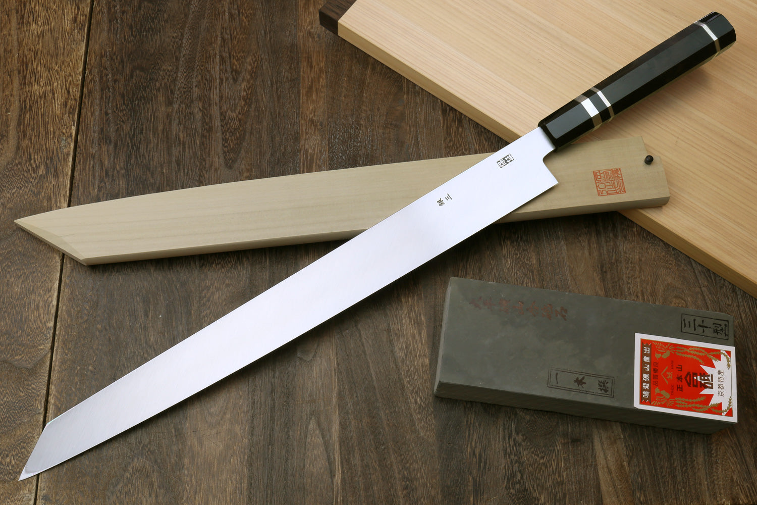 Yanagi-kiritsuke tuna knife with mirror steel blade and ebony handle, with wooden saya