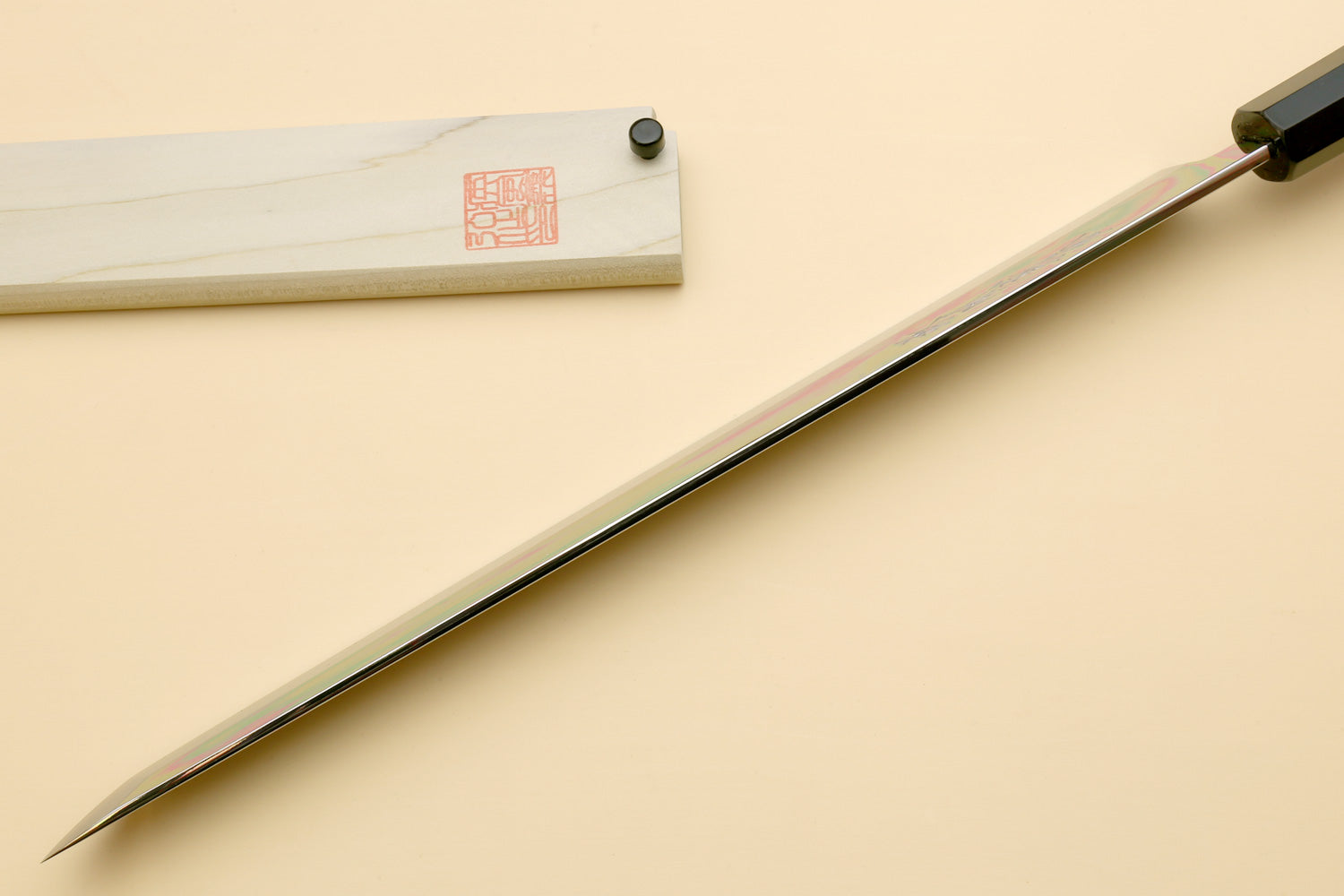 Japanese slicing knife with long, pointed mirror-polished blade and ebony handle