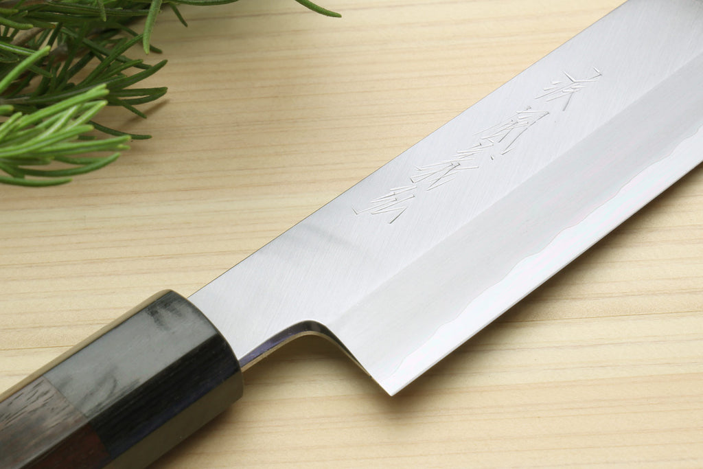 Vegetable knife blade close-up with hammered steel finish and dark bolster