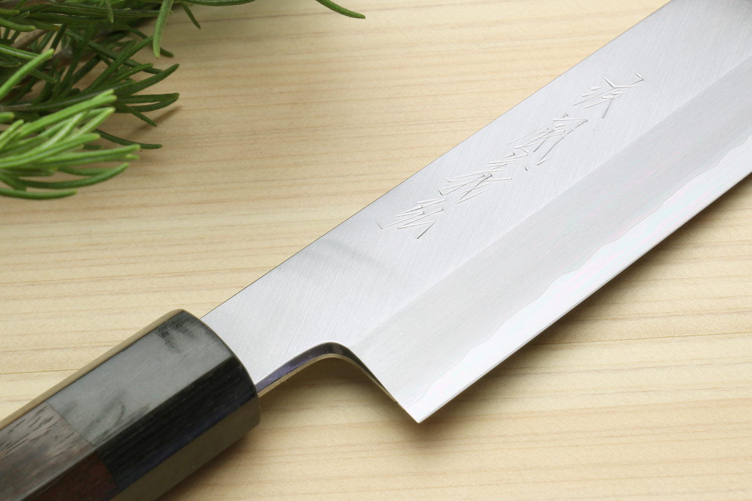 Vegetable knife blade close-up with hammered steel finish and dark bolster