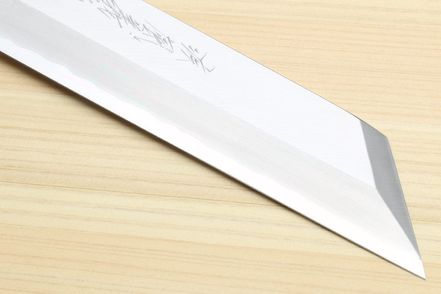 Single-edged vegetable knife tip close-up with sharp pointed edge