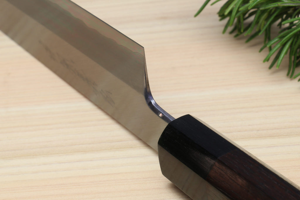 Vegetable knife heel and edge close-up with dark handle and steel blade
