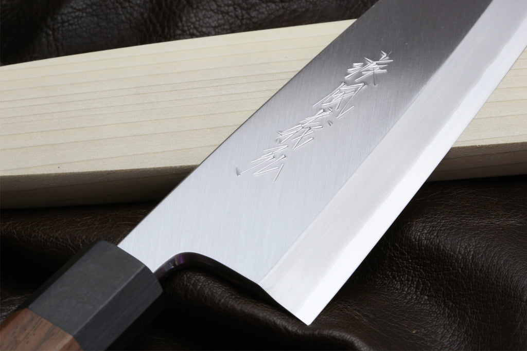 Japanese single-edged filet knife close-up of stamped blade mark and pale face