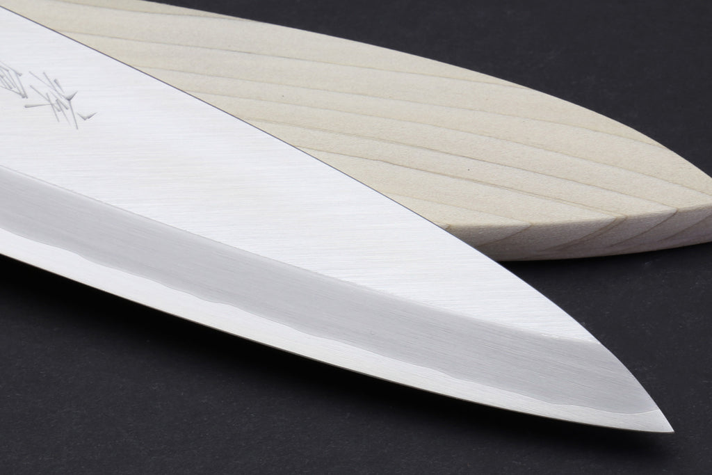 Japanese filet knife close-up of long pale blade with engraved kanji