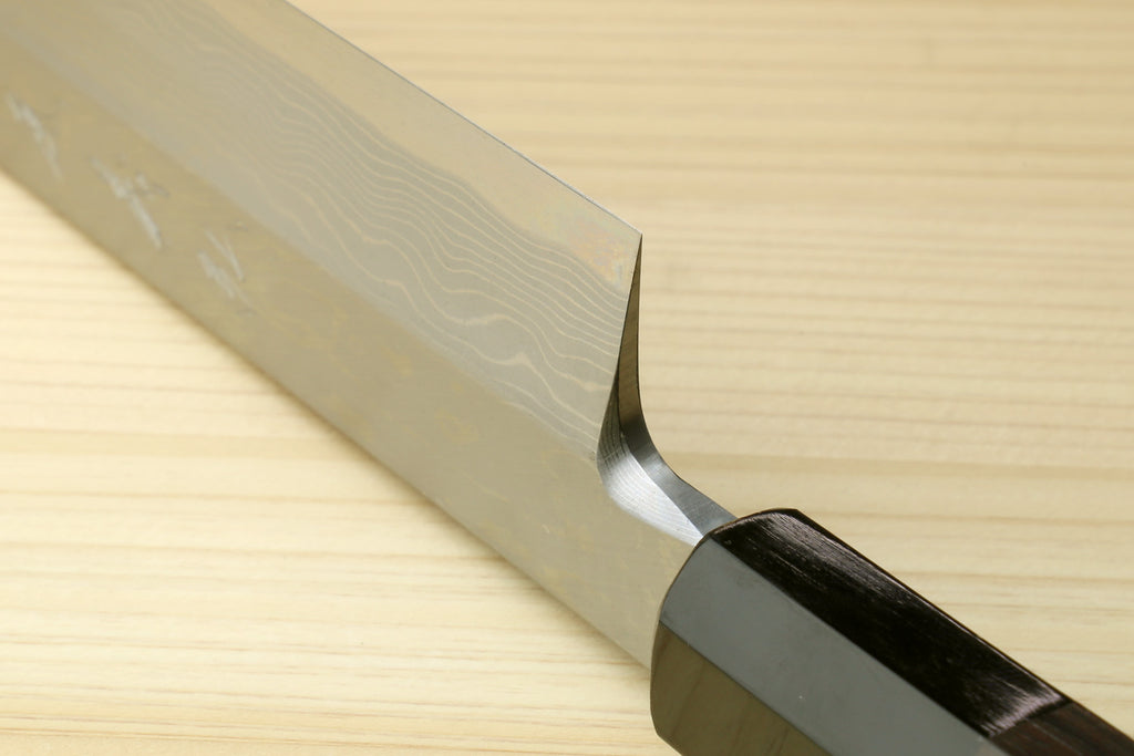 Japanese sushi knife close-up, wavy blade with curved bolster and ebony handle.