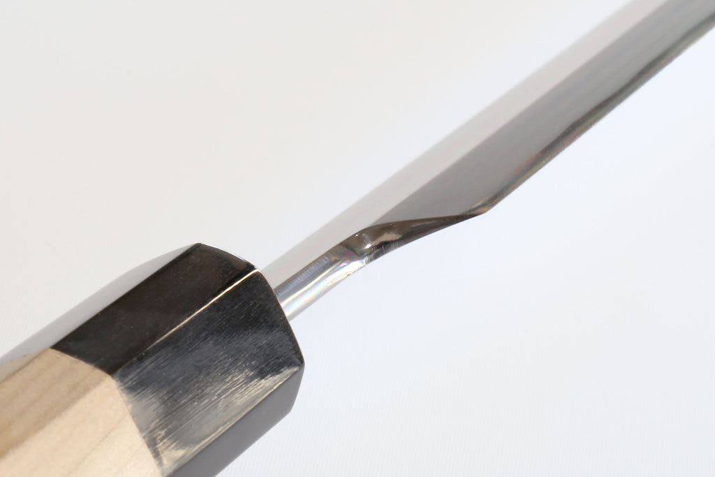 Tuna knife blade edge close-up with black bolster and wood handle