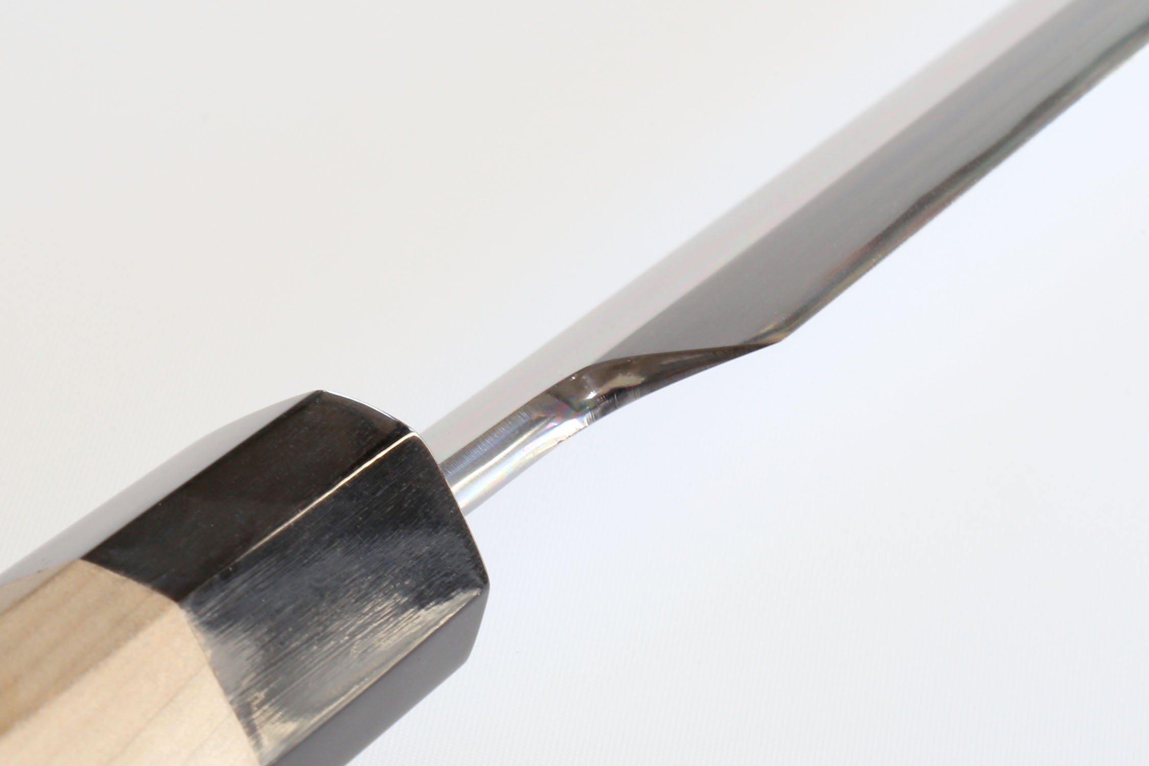 Tuna knife blade edge close-up with black bolster and wood handle
