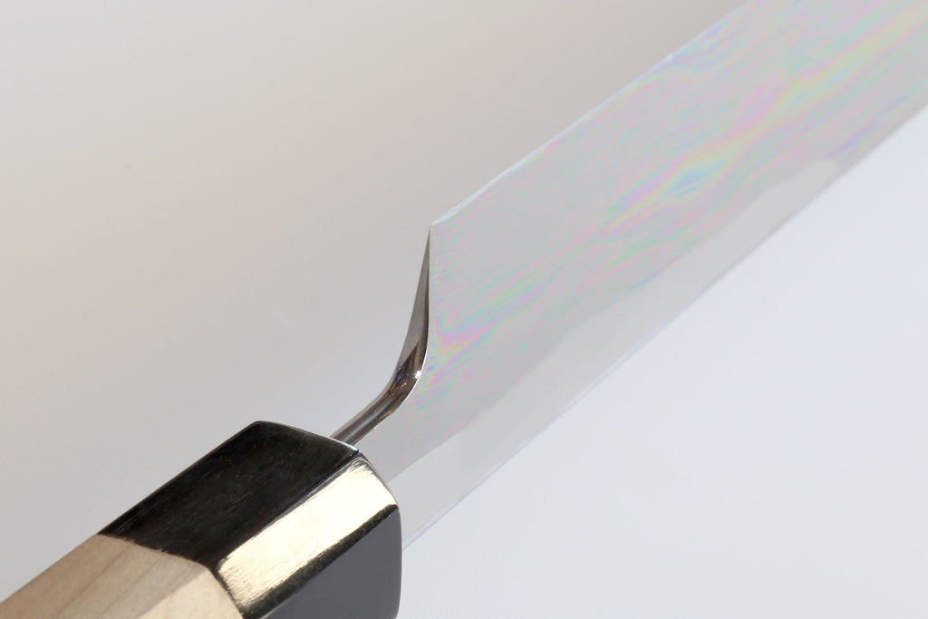 Tuna knife blade tip and black handle end with visible sharpened edge