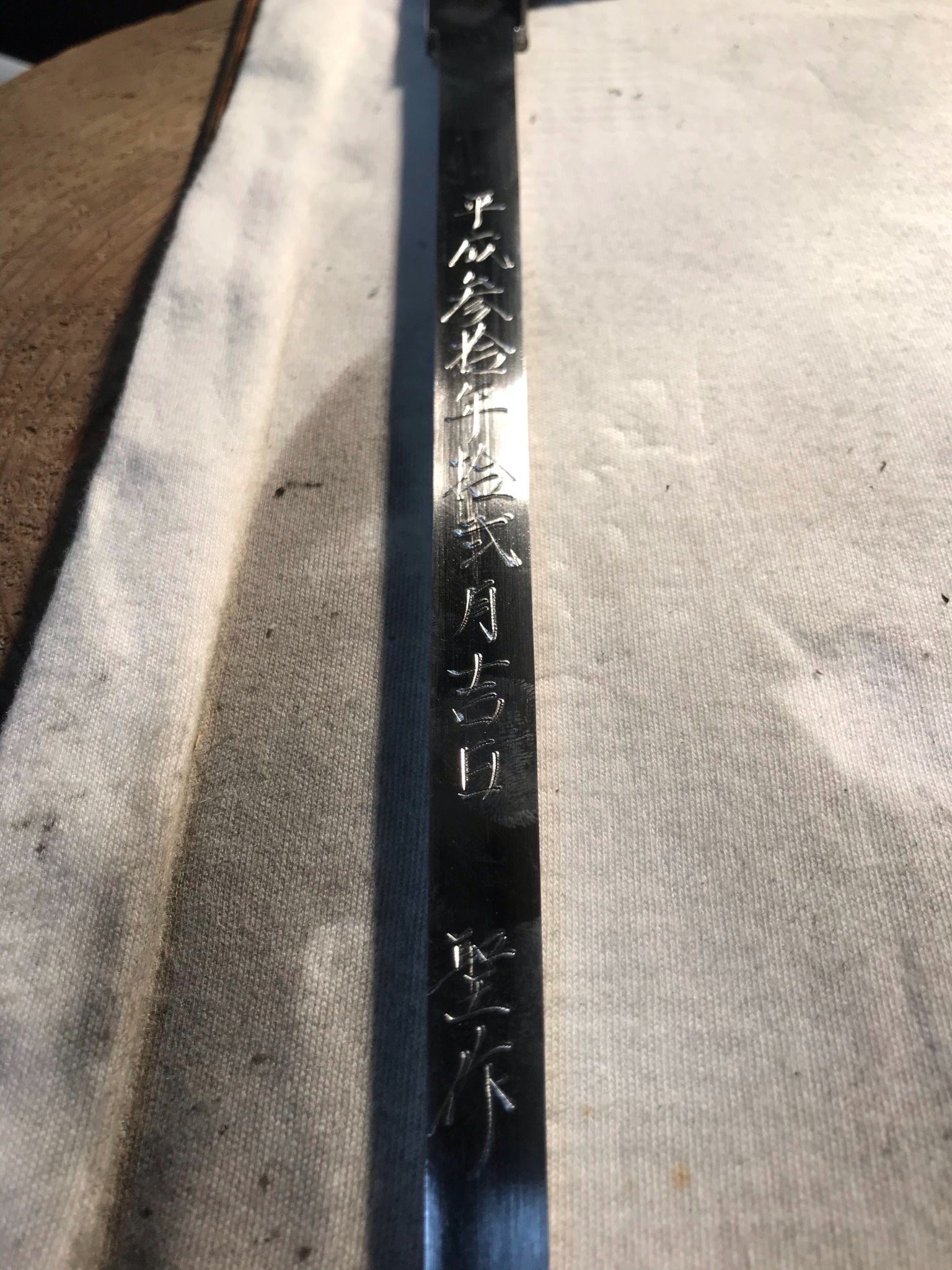 Single-edged tuna knife blade closeup with etched Japanese characters