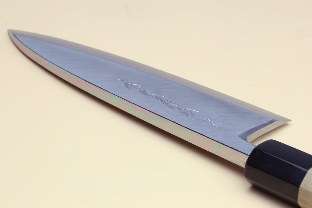 Deba chef knife side view with straight edge and white blade, dark handle