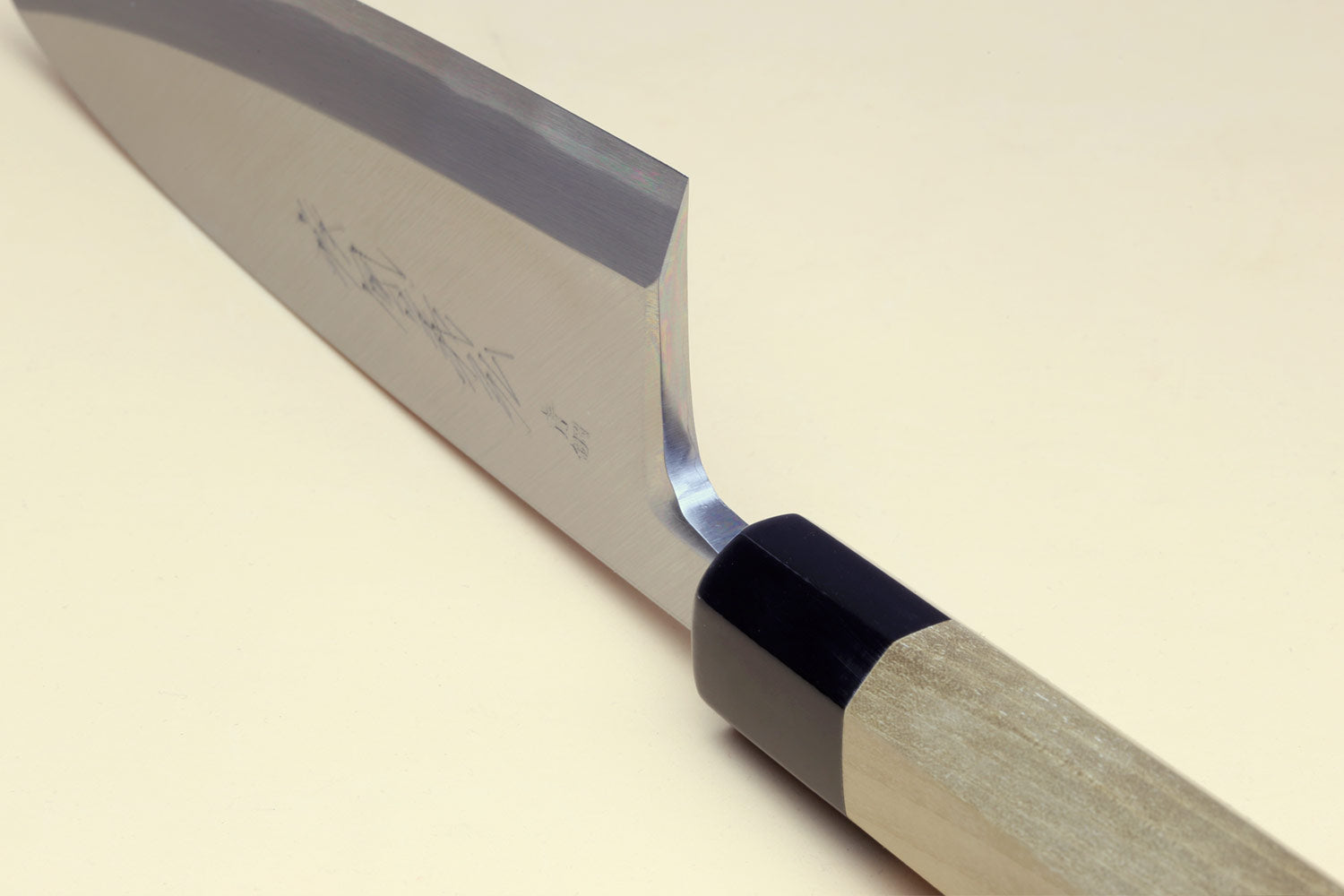 Deba chef knife bolster and edge detail with white blade and dark handle