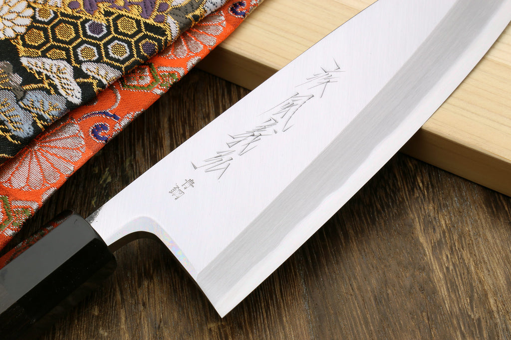 Deba knife blade close-up with engraved mark; ebony handle edge visible