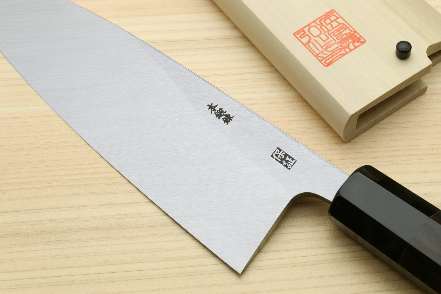 Deba fish knife with silver blade featuring etched symbols and black handle