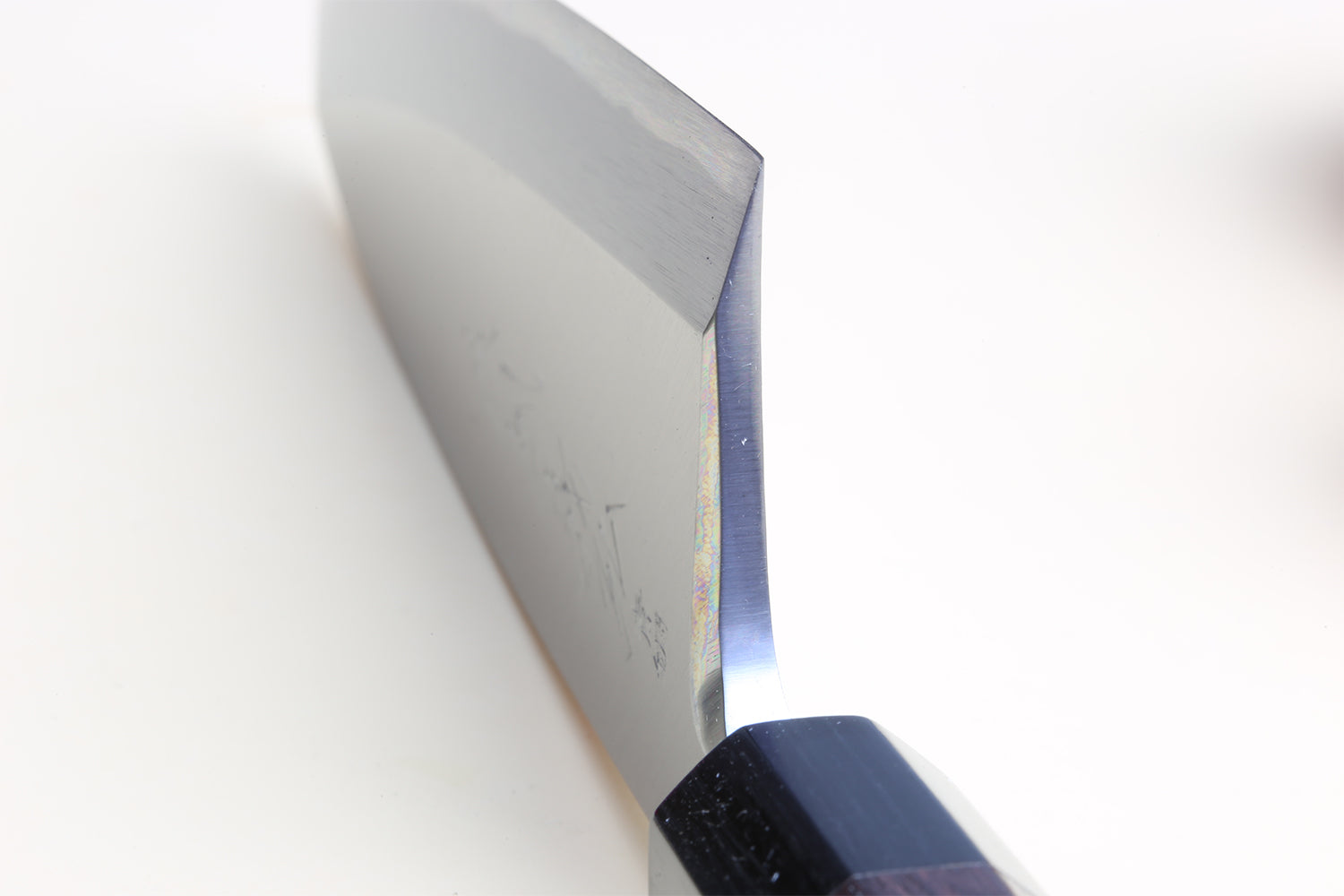 Deba fish fillet knife close-up of steel blade and dark shitan handle