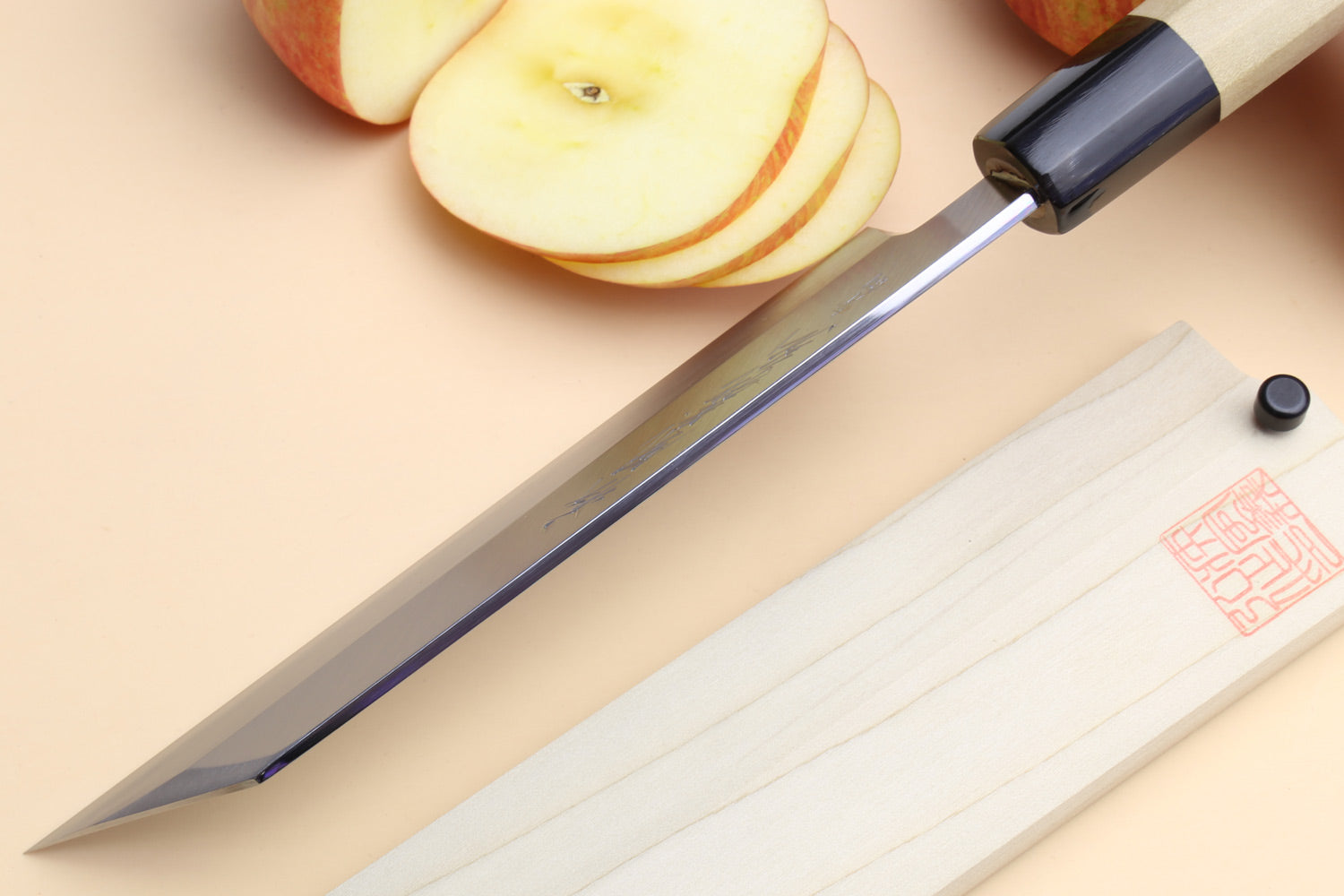 Japanese chef knife with dark collar and light wooden handle, polished steel blade