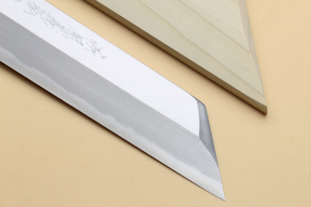 Japanese chef knife blade close-up with etched markings and pointed tip