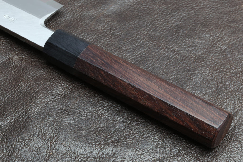 Knife handle close-up with dark brown wood grain and dark end cap on leather