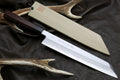 Japanese chef knife with pale blade, dark handle, and antler-style sheath on leather
