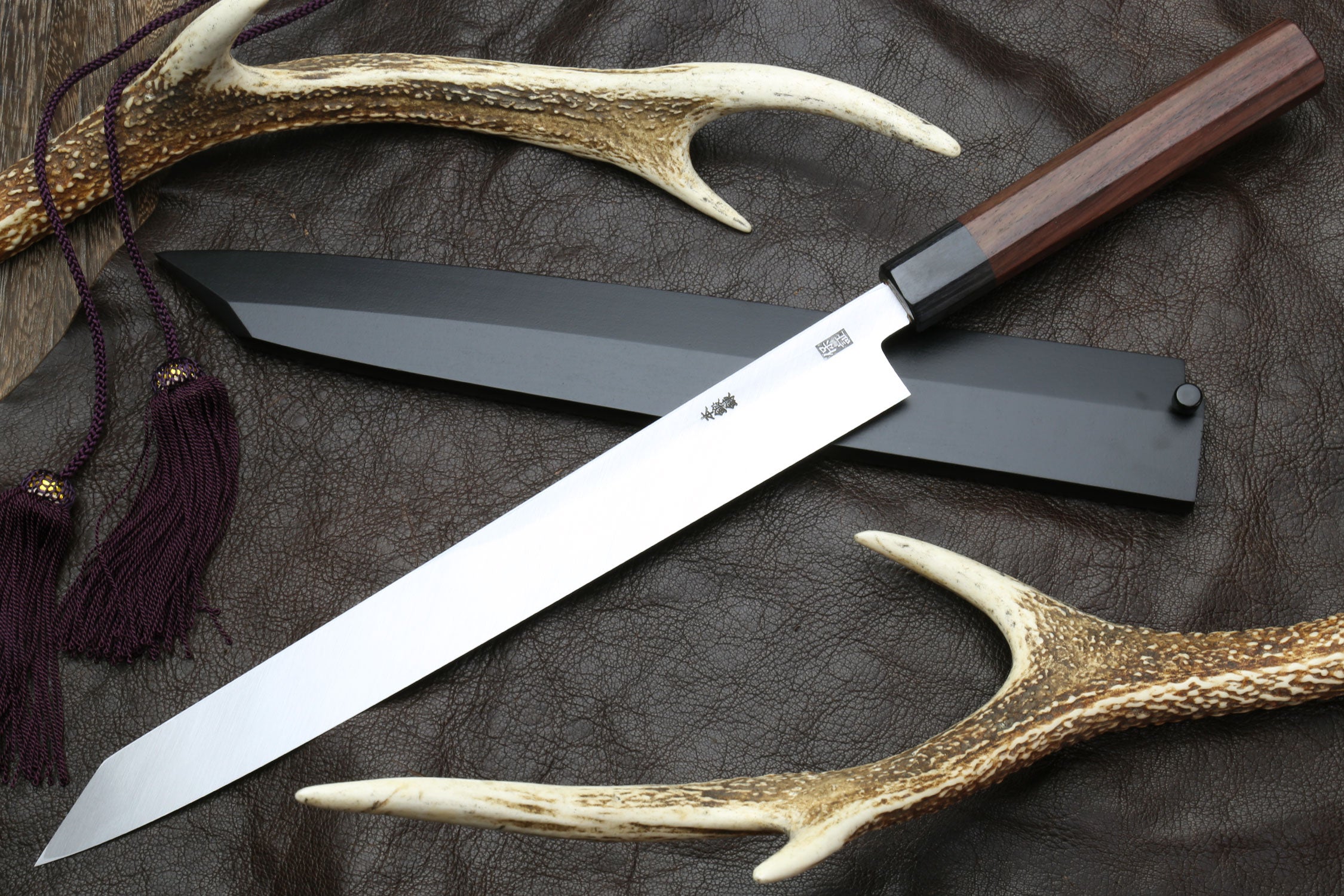 Japanese yanagi-kiritsuke sushi knife showing long blade and rosewood handle
