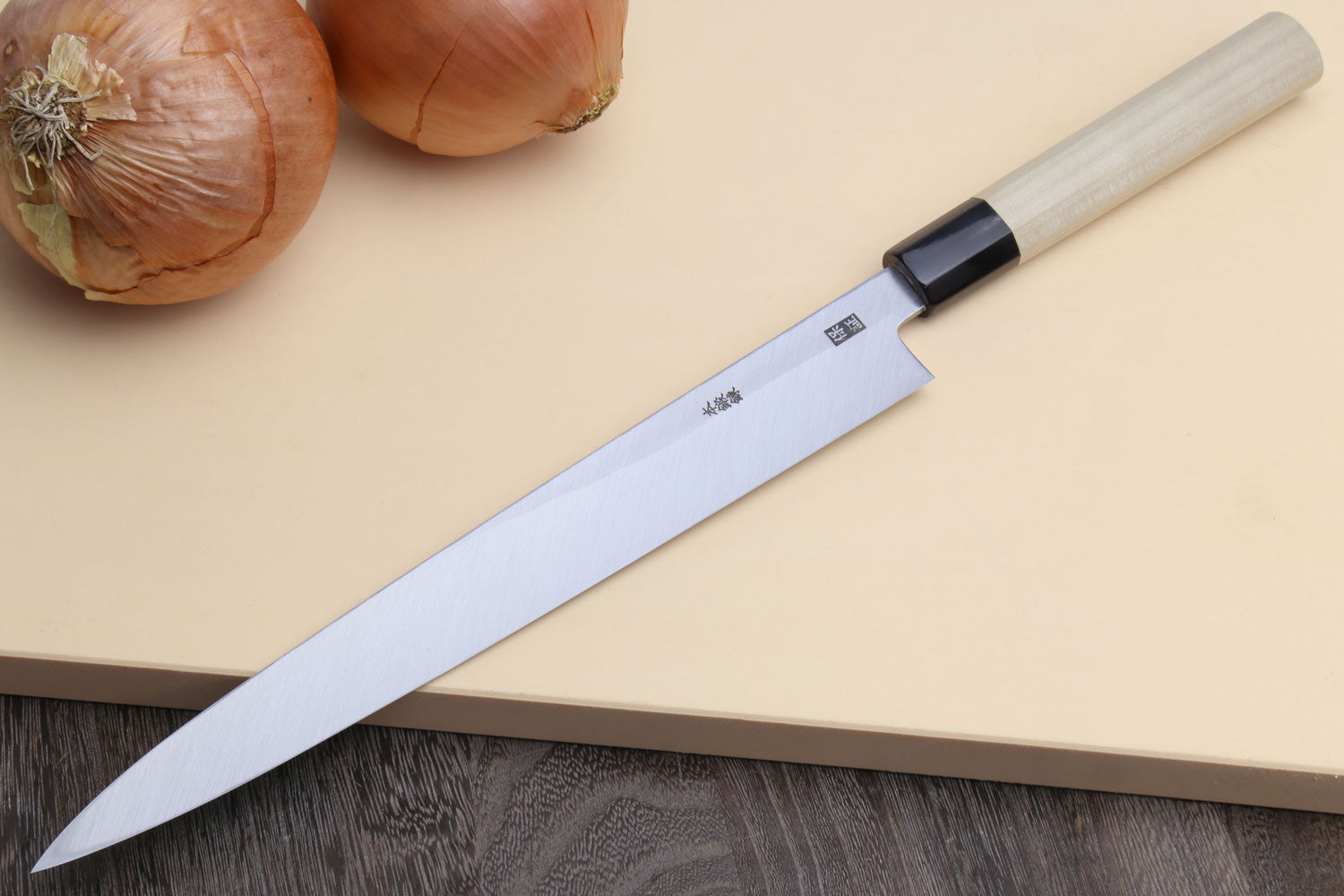 Japanese sashimi knife angled view, silver blade with black bolster and magnolia handle