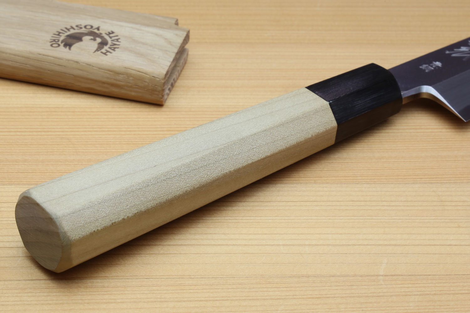 Japanese sashimi knife close view of magnolia handle with black bolster and silver blade